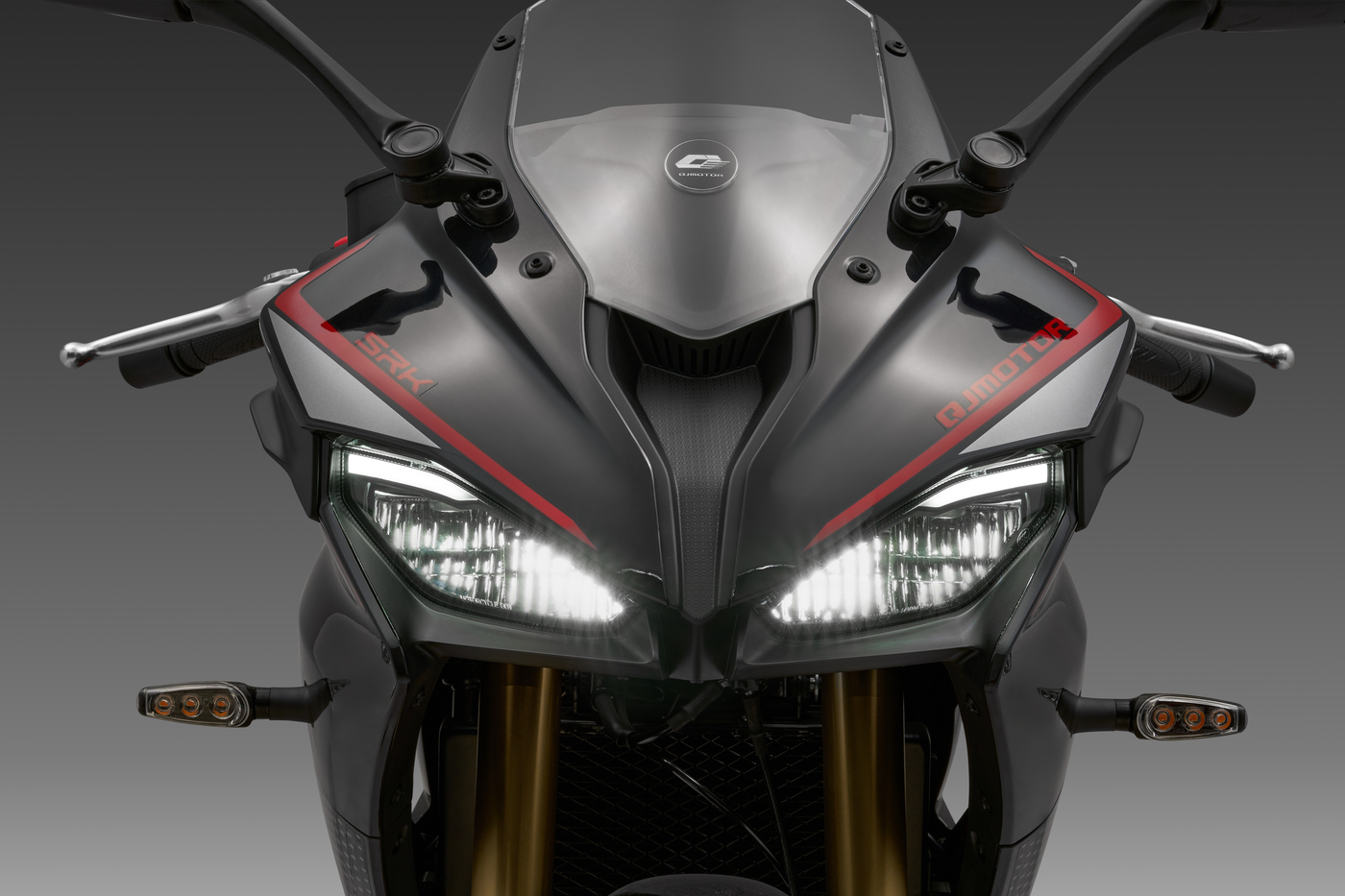 QJMOTOR SRK 125 R: Die Front mit zwei schmalen Scheinwerfern, roten Akzenten und getönter Scheibe.