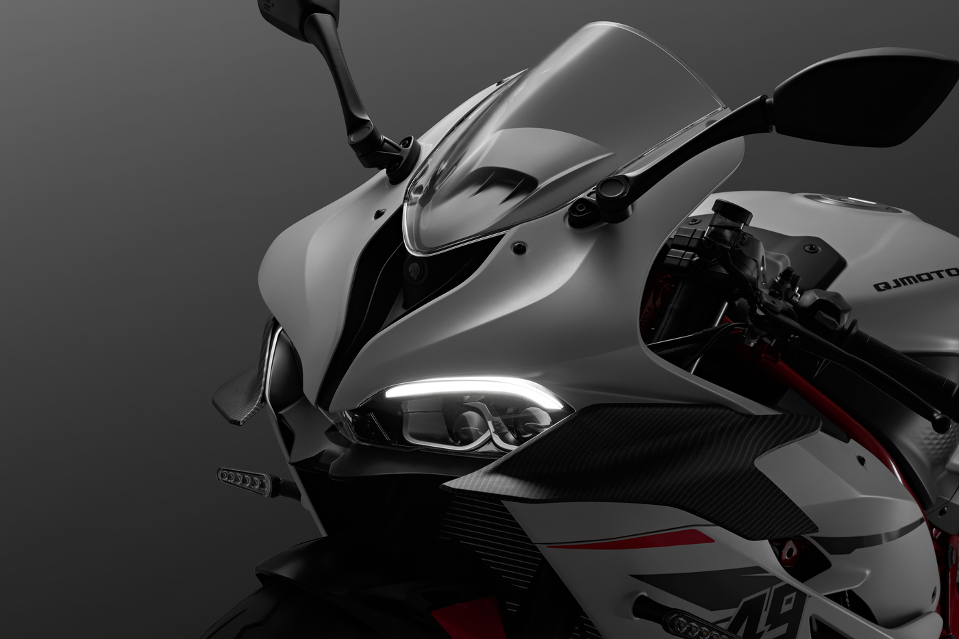 QJMOTOR SRK 921 RR: Die Frontverkleidung mit transparentem Windschild, Spiegel und schmalen Scheinwerferflächen.