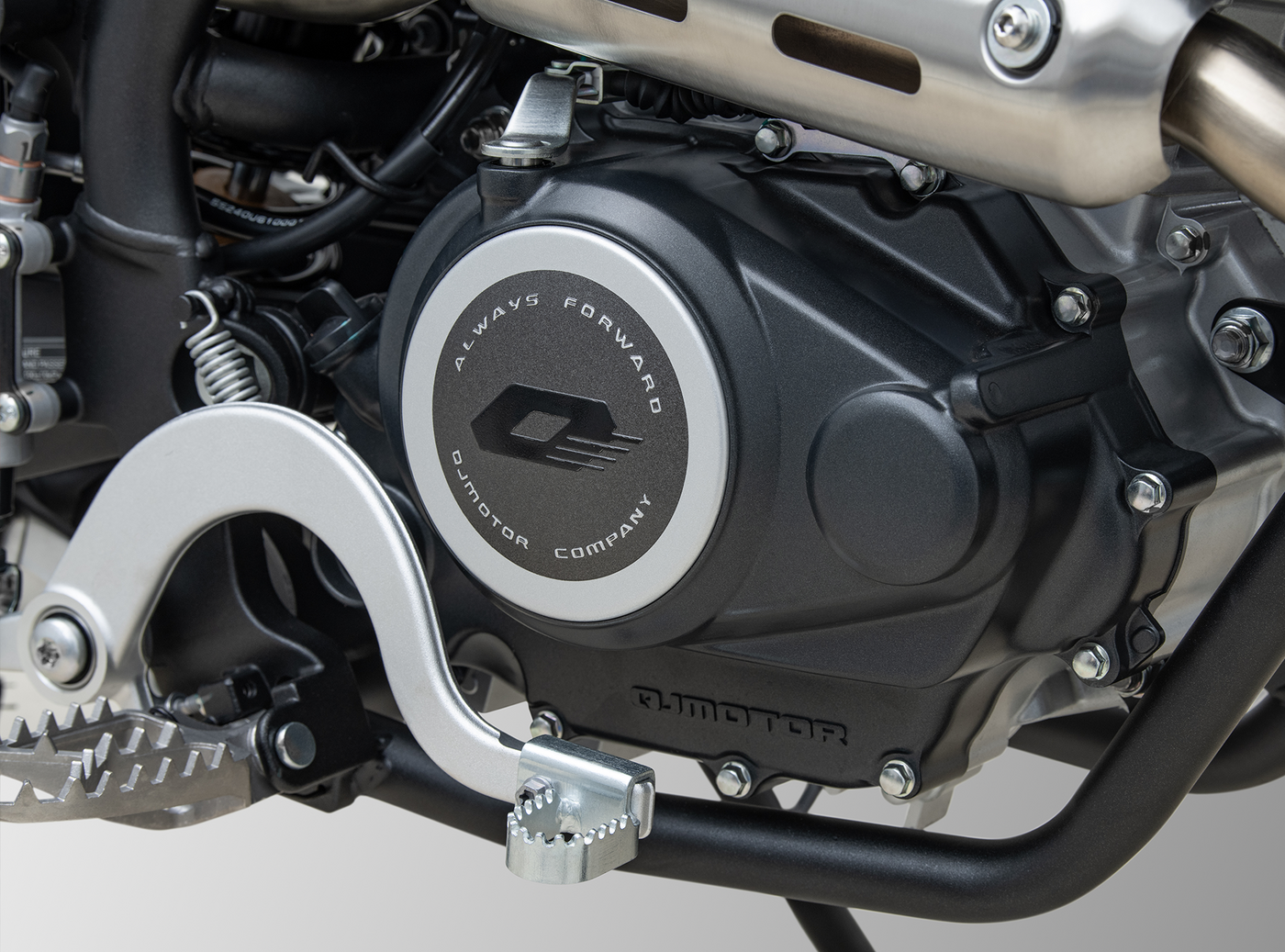 QJMOTOR COV 125 X: Nahaufnahme des Einzylindermotors mit Motorgehäuse, Krümmer und seitlicher Rahmenstruktur.